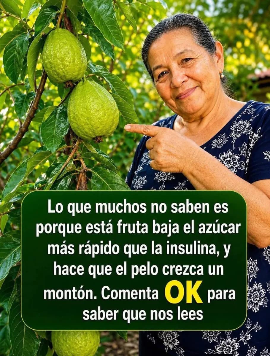 Fruta de guanábana abierta mostrando su pulpa blanca junto a hojas verdes sobre una mesa de madera.